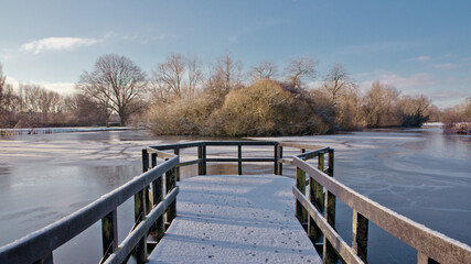 Naklejka premium wooden bridge over the winters lake