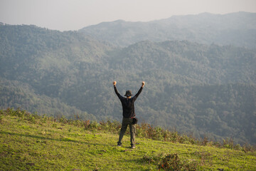 solo backpacker man happy and joyful after success climb the mountain