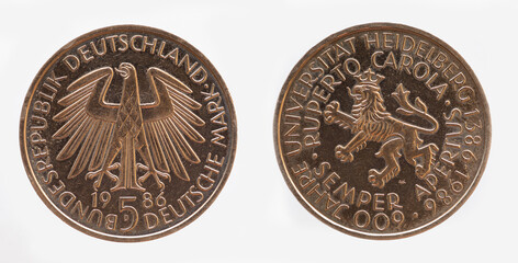 Germany - circa 1986: a 5 DM coin of Germany with the federal eagle and the coat of arms of the University of Heidelberg for the 600 year celebration