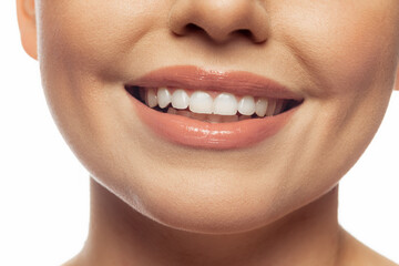 Obraz premium Cropped image of beautiful female lips, teeth, neck and chin isolated over white studio background.