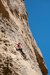 bottom view of man climbing on rock