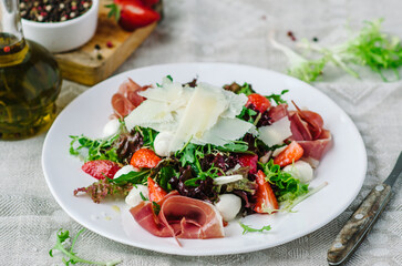 Salad mix with jamon, baby mozzarella, strawberries and vinaigrette sauce.