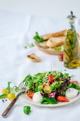 Salad with strawberries, cherry tomatoes, sunflower seeds, spinach and feta cheese on white background. Top view
