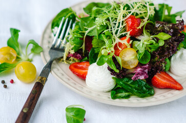 Salad with strawberries, cherry tomatoes and mixed salad