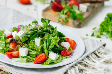 Fresh salad with feta cheese, strawberry and and salad mix