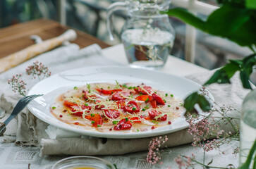 sea bass carpaccio with baked strawberries and citrus dressing. Dish in the restaurant, strawberry...