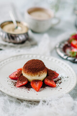 Italian dessert tiramisu with strawberries on an old grunge background. Round tiramisu dessert