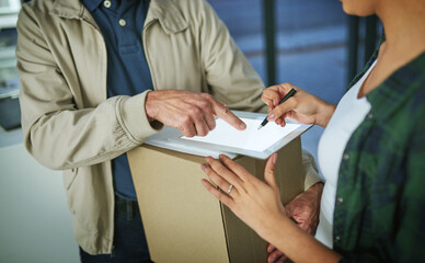 An electronic signature releases her package. Cropped shot of a woman using a digital tablet to sign for a package from a delivery man.