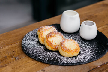 Cheese pancakes, homemade traditional Ukrainian and Russian matches, selective focus. Cheesecakes on a plate.