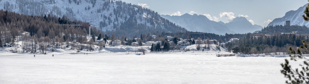 people on frozen mountain lake and mountain village, near Maloja, Switzerland