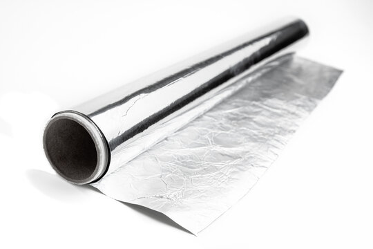 Food grade aluminum foil paper for packaging. Shiny aluminum wrap on a white background. Texture of crumpled aluminium food foil.