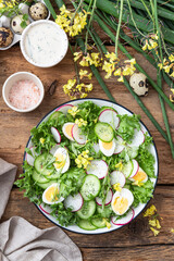 Spring salad with cucumbers and radishes on a wooden background	