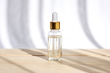Naklejka premium Natural oil cosmetics. Dropper glass Bottle Mock-Up. Oily cosmetic pipette. Face and body treatment. Spa concept. Mineral organic liquid. Front view. Beauty products. Blank packaging on wooden table