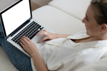 Mockup image of a woman using and typing on laptop computer keyboard with blank white desktop screen.