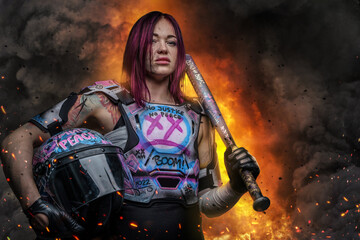 Obraz premium Strong woman with pink hairs holding baseball bat agains explosion