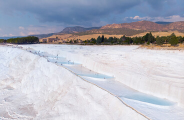 Natural travertine pools blue water and terraces in Pamukkale Turkey aerial top view
