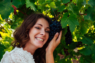 portrait of a beautiful woman in a vineyard of wine and juice