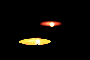 Two burning candles on the table in honor of the commemoration in the dark.Burning candles on dark surface