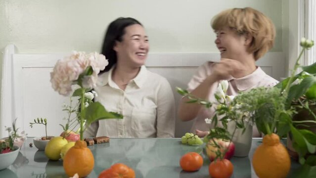 women smile and dance in kitchen