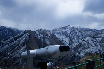 binoculars for observation on the background of winter mountains