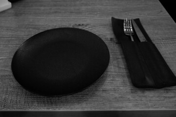 black plate with cutlery on black and white photo