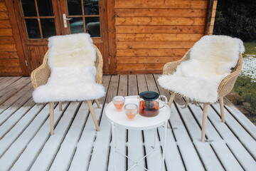 Fototapeta na wymiar Nice wooden hut in a garden with snow. Garden shed with chairs in winter. Winter mood. Drinking tea outside by cold in winter. snow in Germany. garden in winter. holiday house