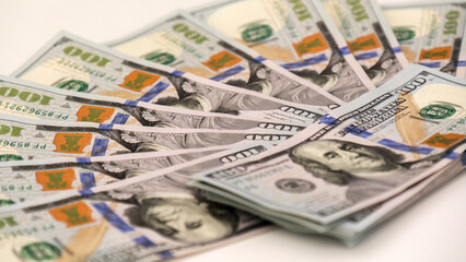 A sheet of new hundred dollar bills are laid out on the table, in a row and in a circle. Great background for filling.