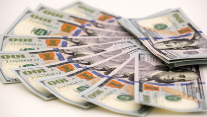 A sheet of new hundred dollar bills are laid out on the table, in a row and in a circle. Great background for filling.