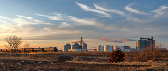 Farmland producing ethanol for the oil and gas industry.  Railroad tankers cars lined up near a...