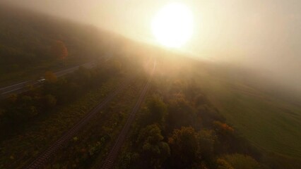 Aerial FPV flight over foggy mountains, open inspiring nature landscape and sunrise sunshine. Misty morning. Birdseye travel. Drone footage.