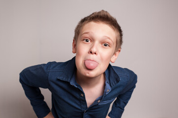 A playful boy showing his tongue on a camera