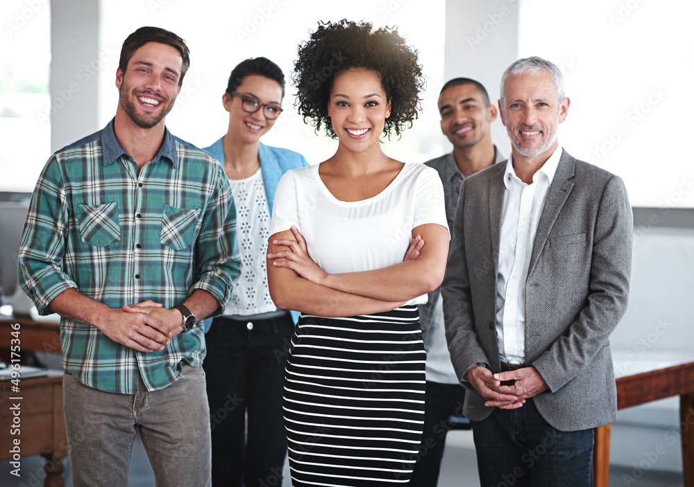 Poster ready for any challenge. portrait of a group of smiling coworkers standing in an office.
