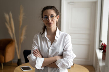 A freelance woman with glasses in the office in a white shirt