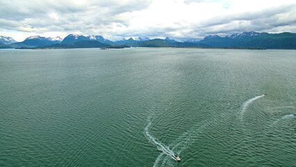 Aerial photo of fishing boats moving in and out of the Homer, Alaska boat harbor.  Summer.