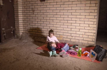 Poster KIEV, UKRAINE - March 24, 2022: The war in Ukraine. the life of children in a bomb shelter at a metro station in Ukraine. © Tatsiana