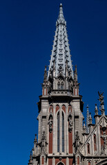 Fototapeta na wymiar Peak of gothic style catholic church with blue sky in back