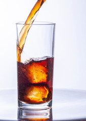 Glasses of cola with ice cubes served with a splash