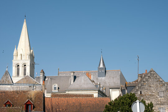 Tile and slate roofs and abbey church tower in Beaulieu les Loches on a sunny spring afternoon, Loire valley, France