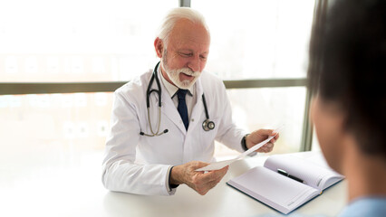 Older doctor looking at patients results