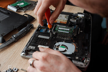 Fototapeta na wymiar Man repairs laptop by himself, computer repair