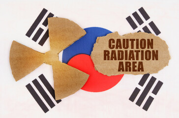 On the flag of South Korea, the symbol of radioactivity and torn cardboard with the inscription caution radiation area