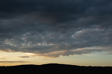Obraz premium Meadow and hills and clouds before a thunderstorm.
