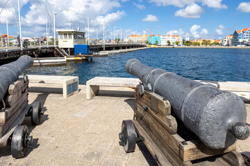 Cannon pointing at the famous queen emma bridge and buildings of Otrobanda in Willemstad, Curacao