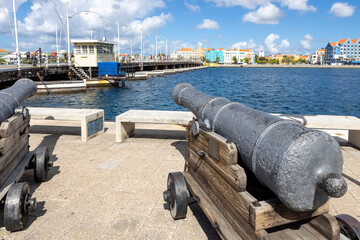 Cannon pointing at the famous queen emma bridge and buildings of Otrobanda in Willemstad, Curacao