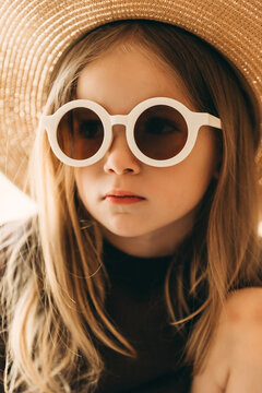 stylish studio portrait of a little girl in white-rimmed glasses