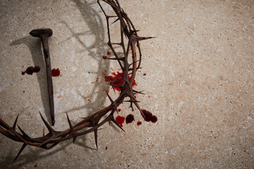 Easter concept. Crown of thorns with Nail and blood drops on a stone background.