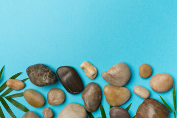 Spa stones and leaves on wooden background, top view
