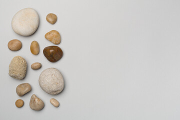 Fototapeta na wymiar Set of sea stones on color background, top view