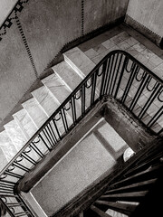 Black and White photo of an old residential stairs with metallic handrails 