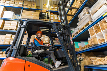 Young female forklift driver working in a warehouse